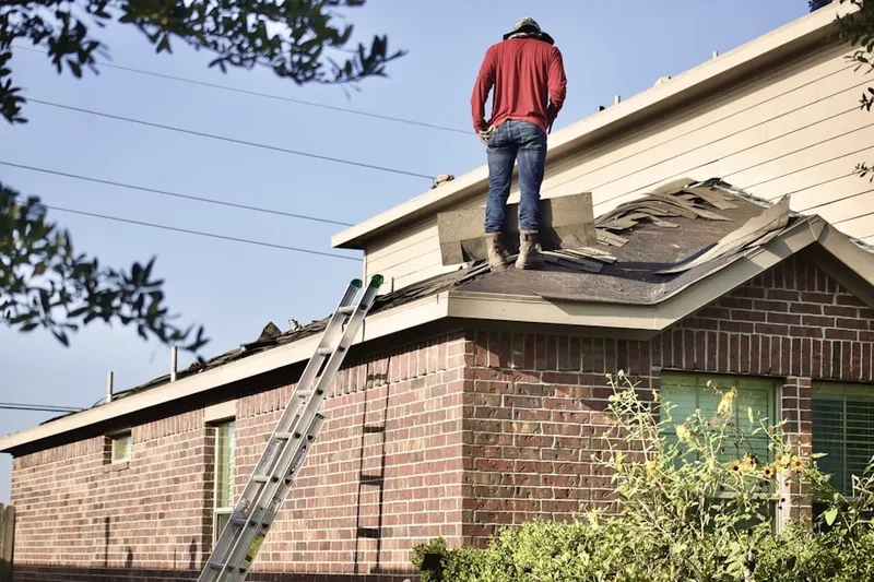 Professional roofer working on a residential roof in Claymont Manor